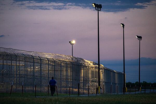 A Management & Training Corporation employee patrols the exterior of the Bluebonnet Detention Center Thursday, April 24, 2025, in Anson, Texas (AP Photo/Eli Hartman)