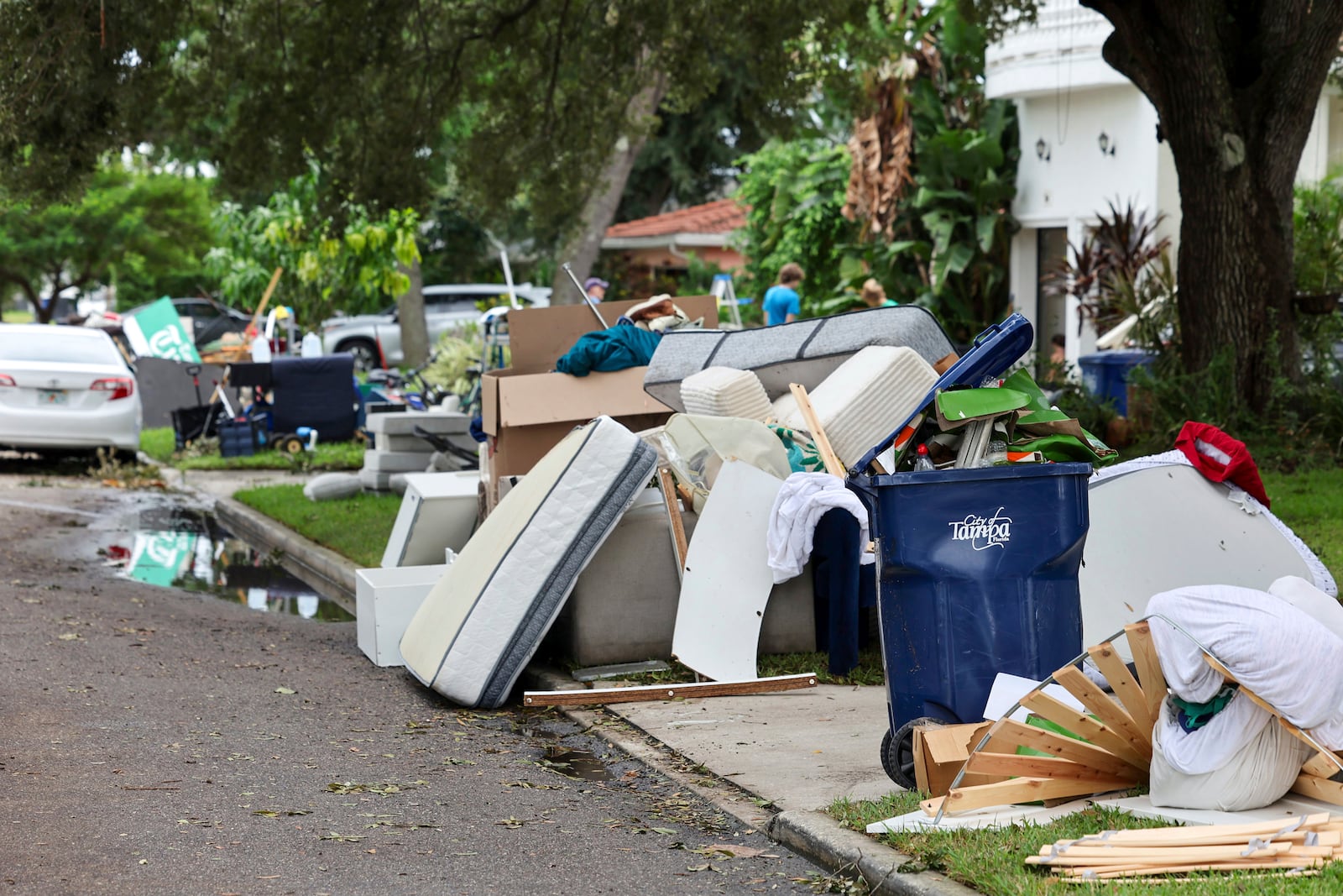 Contents of homes are piled on the side of the road after flooding from Hurricane Helene on Davis Island Saturday, Sept. 28, 2024, in Tampa, Fla. (AP Photo/Mike Carlson)