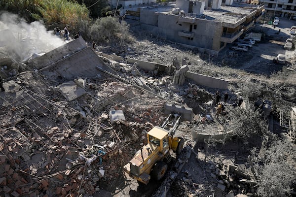 Civil defense workers check the site of a building that collapsed after it was hit by an Israeli airstrike in Hadath, south of Beirut, Lebanon, Sunday, Nov. 17, 2024. (AP Photo/Bilal Hussein)