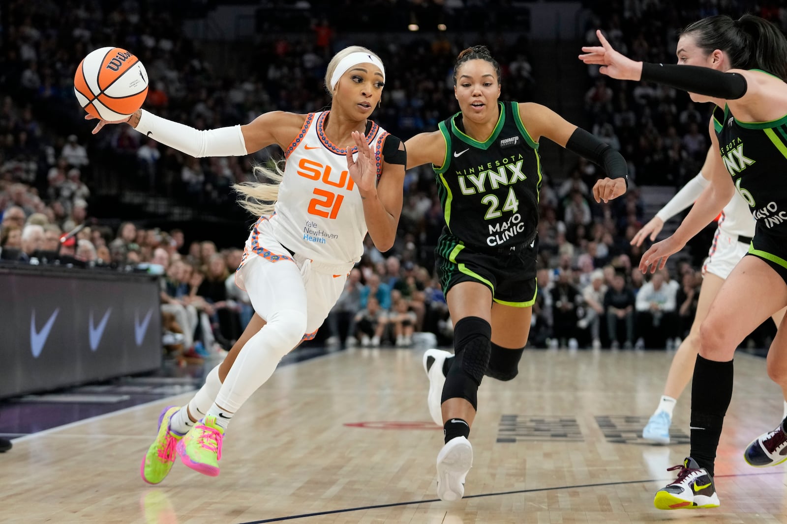 Connecticut Sun guard DiJonai Carrington (21) works toward the basket as Minnesota Lynx forward Napheesa Collier (24) defends during the first half of Game 5 of a WNBA basketball semifinals, Tuesday, Oct. 8, 2024, in Minneapolis. (AP Photo/Abbie Parr)