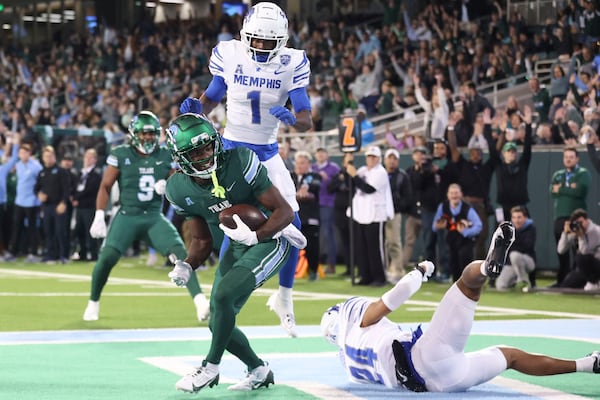 Tulane Green Wave wide receiver Mario Williams (4) catches a seven yard touchdown pass against Memphis Tigers defensive back Greg Rubin (24) during first half action in New Orleans on Thursday, Nov. 28, 2024. (AP Photo/Peter Forest)