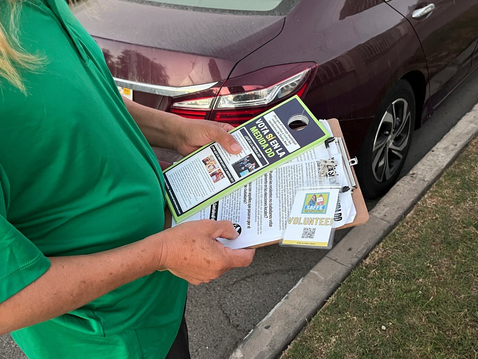 Volunteers go door-knocking on Wednesday, Oct. 23, 2024, in a Santa Ana neighborhood to encourage them to vote for Measure DD, which would allow noncitizens to vote in local elections. (AP Photo/Jaimie Ding)