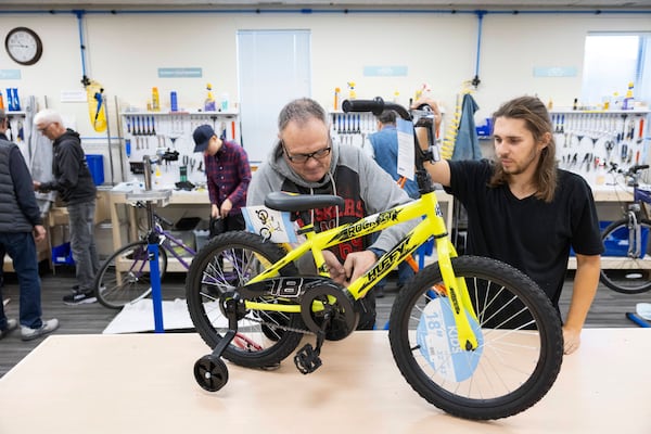 Volunteer and board member Kurt Glathar, left, works on a children's bicycle alongside fellow volunteer Simon Zacher at Lincoln Bike Kitchen on Tuesday, Nov. 12, 2024, in Lincoln, Neb. (AP Photo/Rebecca S. Gratz)