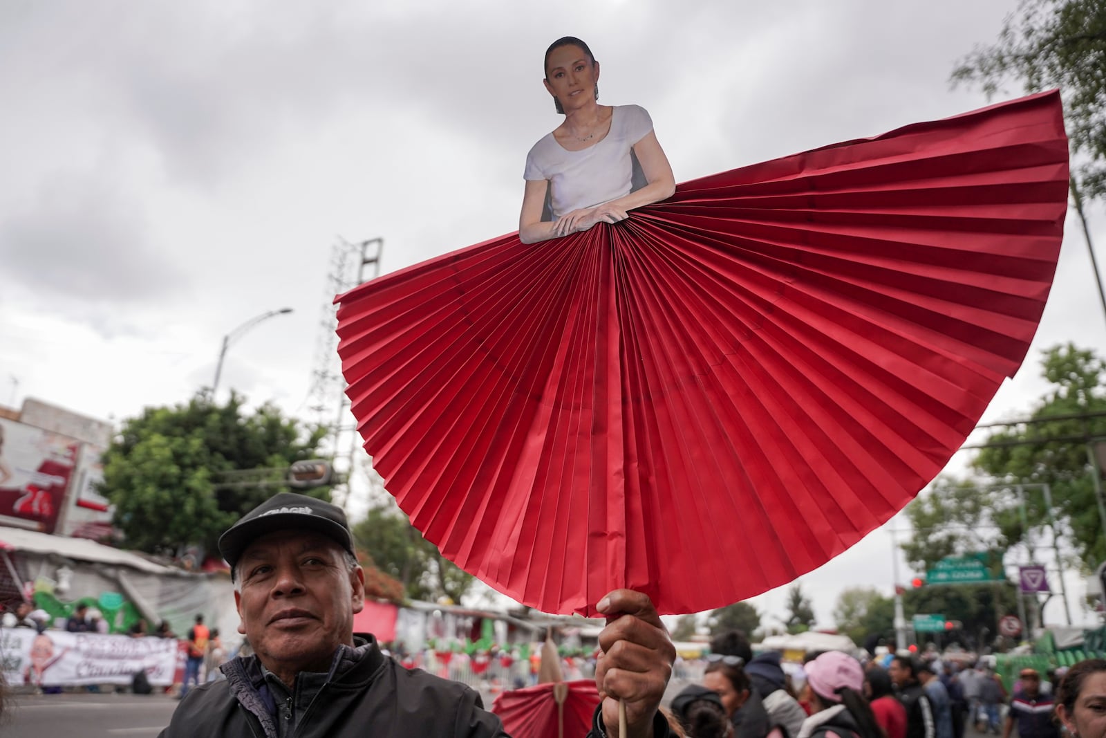 A supporter carries a cutout of President Claudia Sheinbaum during a rally to hear her speak on her inauguration day at the Zocalo, Mexico City's main square, Tuesday, Oct. 1, 2024. (AP Photo/Aurea Del Rosario)