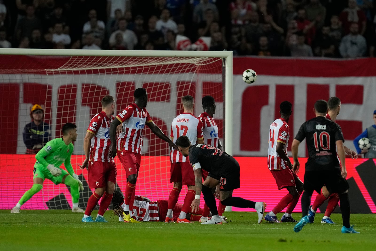 Benfica's Orkun Kokcu, right, scores a free kick, his side's second goal during the Champions League opening phase soccer match between Red Star and SL Benfica, at the Rajko Mitic Stadium in Belgrade, Serbia, Thursday, Sept. 19, 2024. (AP Photo/Darko Vojinovic)