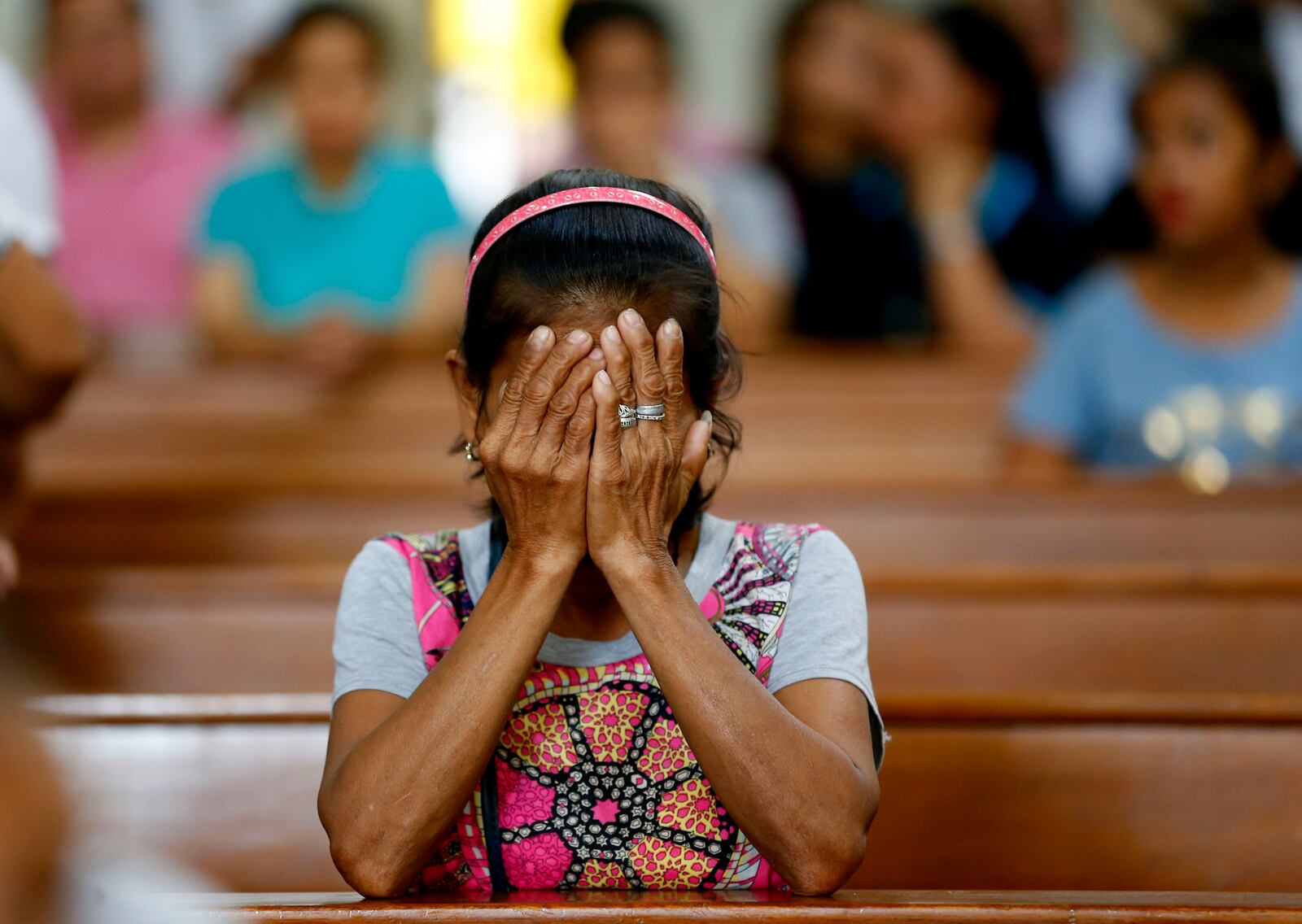 FILE - A relative of a victim in President Rodrigo Duterte's so-called war on drugs reacts during a church service in Manila, Philippines, Mach 17, 2019. (AP Photo/Bullit Marquez, File)