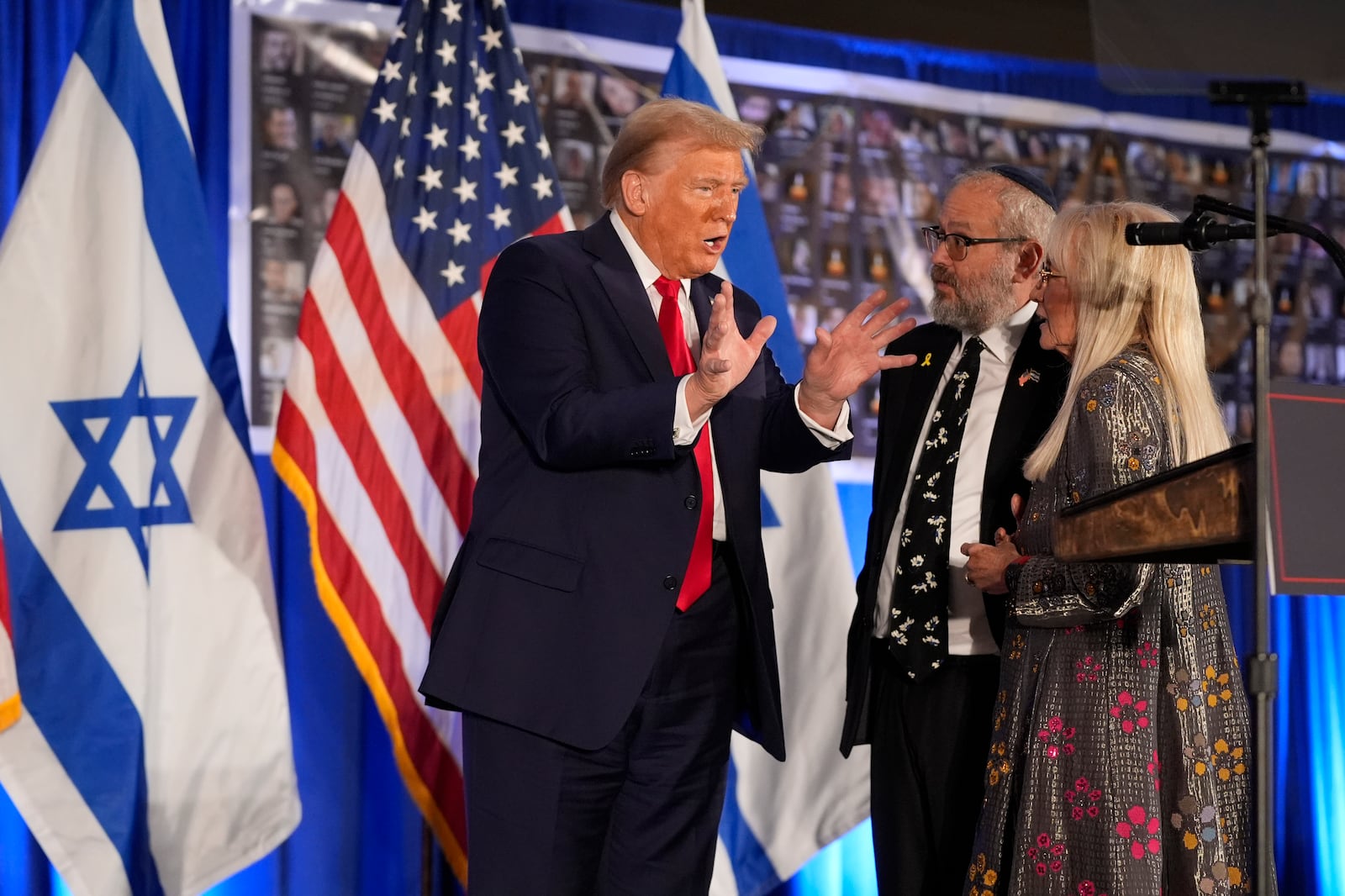 Republican presidential nominee former President Donald Trump talks with Miriam Adelson and Rabbi Yeshuda Kaploun at an event marking one year since the Oct. 7 Hamas attack on Israel, Monday, Oct. 7, 2024, in Miami. (AP Photo/Alex Brandon)