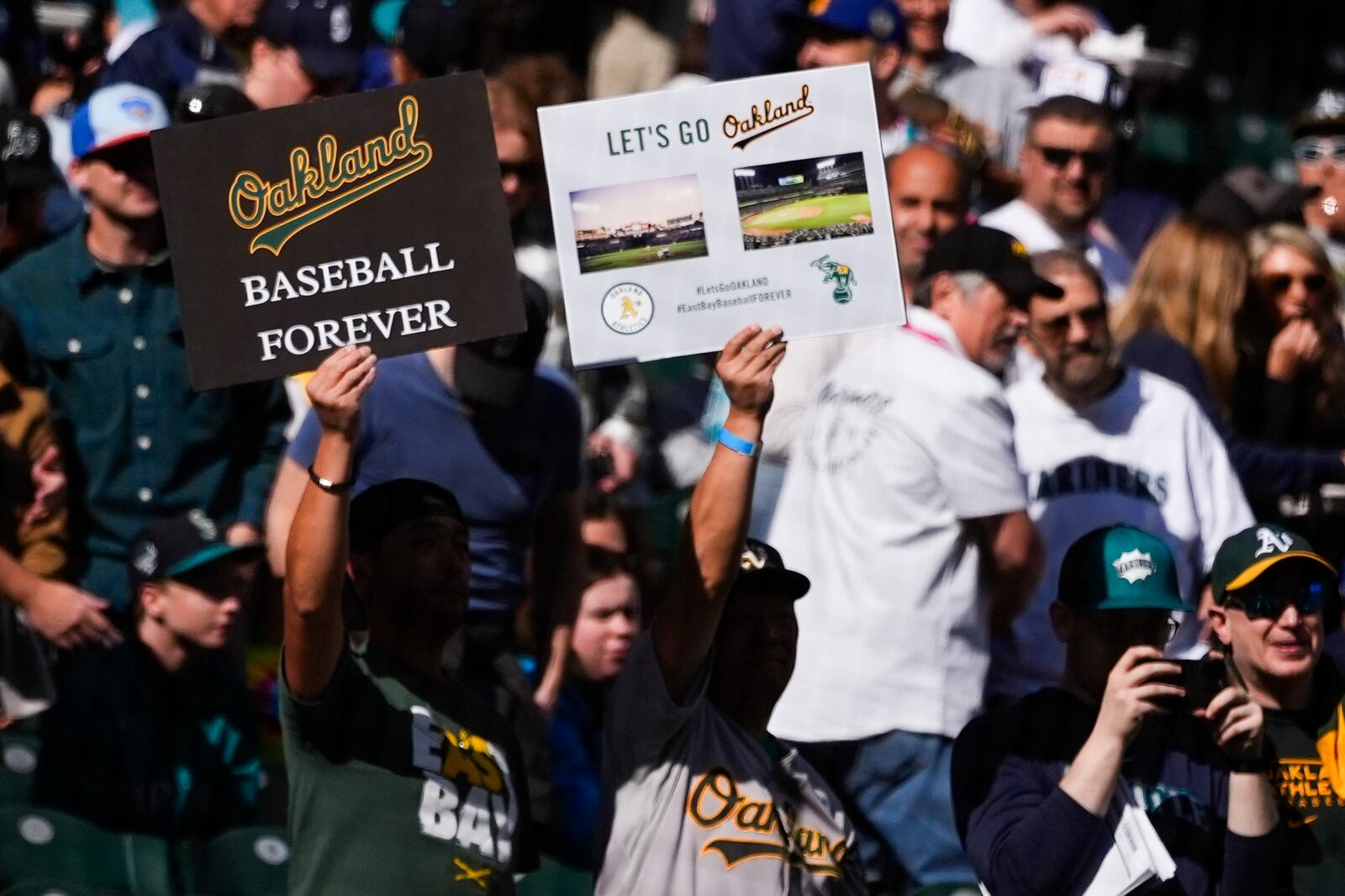 Fans hold signs for the Oakland Athletics before a baseball game between the Athletics and the Seattle Mariners, Sunday, Sept. 29, 2024, in Seattle. (AP Photo/Lindsey Wasson)