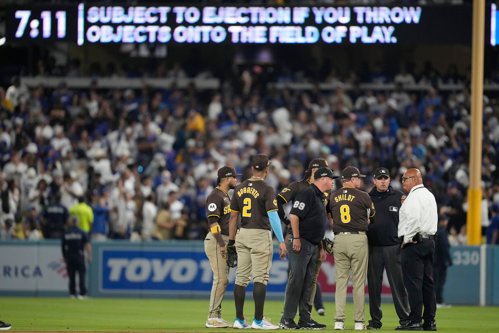 San Diego Padres manager Mike Shildt (8) and players talk to umpires after items were thrown on the field by fans during the seventh inning in Game 2 of a baseball NL Division Series against the Los Angeles Dodgers, Sunday, Oct. 6, 2024, in Los Angeles. (AP Photo/Ashley Landis)