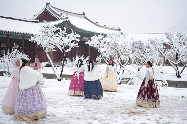 Visitors enjoy in snow at the Gyeongbok Palace, one of South Korea's well-known landmarks, in Seoul, South Korea, Wednesday, Nov. 27, 2024. (AP Photo/Lee Jin-man)