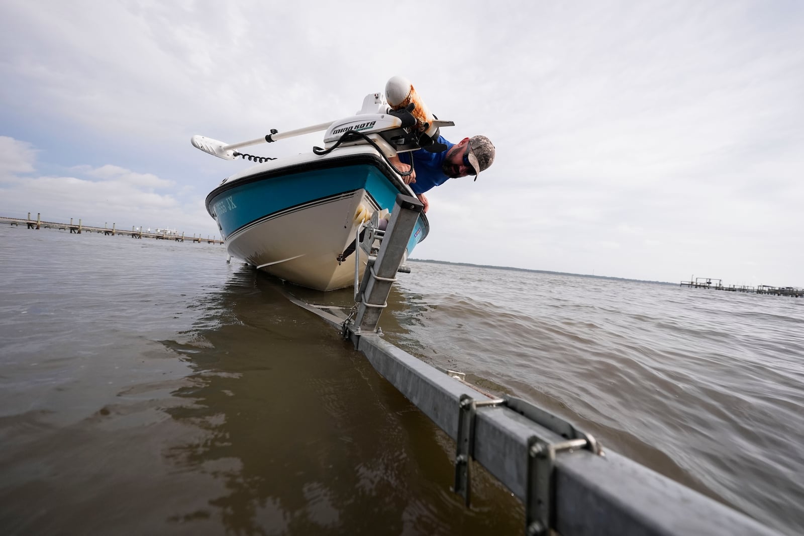 Bo Manausa pulls his boot out of the water ahead of Hurricane Helene, expected to make landfall Thursday evening, in Alligator Point, Fla., Wednesday, Sept. 25, 2024. (AP Photo/Gerald Herbert)