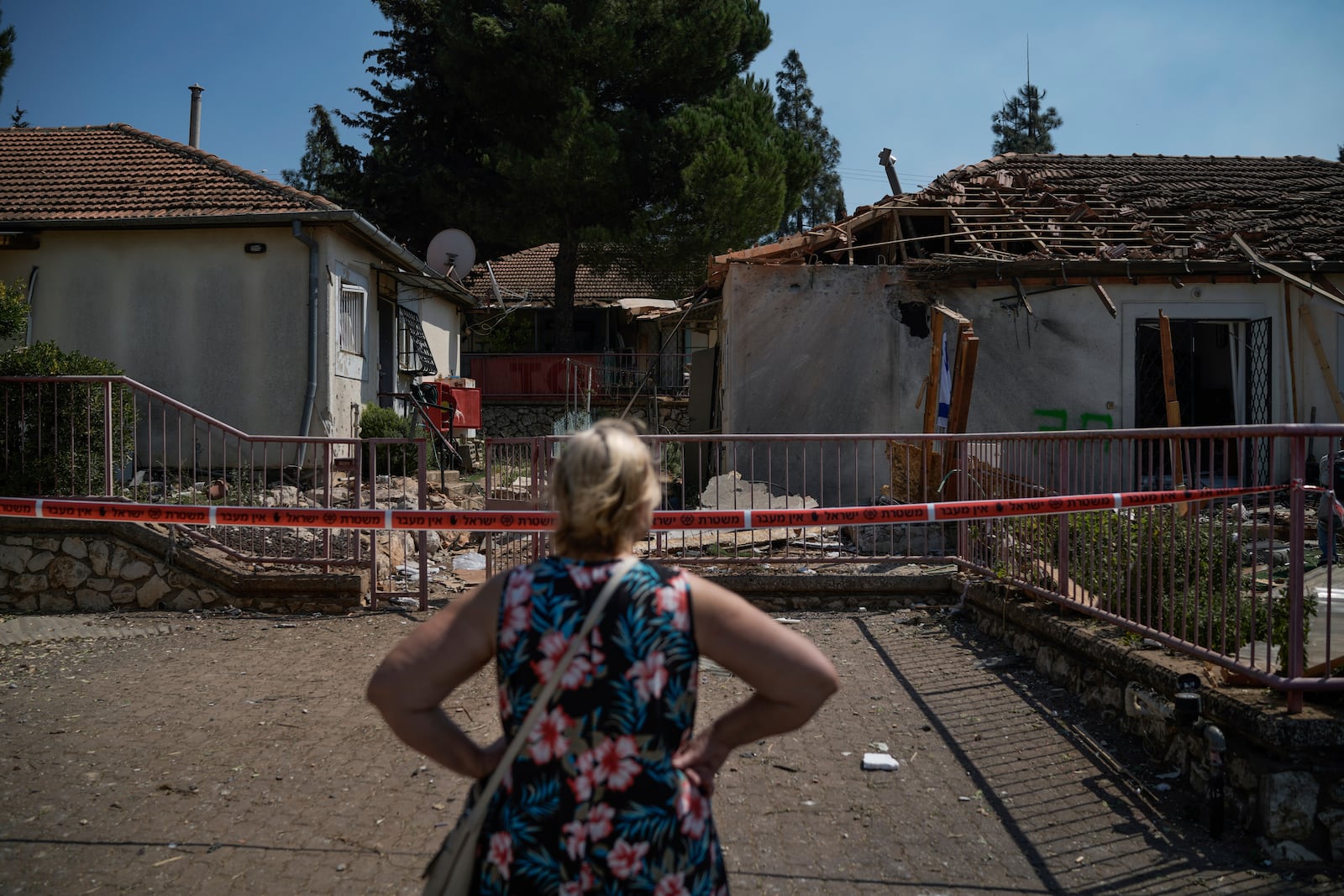 A woman looks at a damaged house that was hit by a rocket fired from Lebanon, near Safed, northern Israel, on Wednesday, Sept. 25, 2024. (AP Photo//Leo Correa)