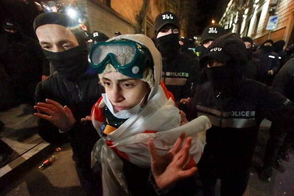 Police push a demonstrator away as they other blocked protesters pouring into the streets following Georgian Prime Minister Irakli Kobakhidze's announcement, rallying outside the parliament building in Tbilisi, Georgia, on Friday, Nov. 29, 2024. (AP Photo/Zurab Tsertsvadze)