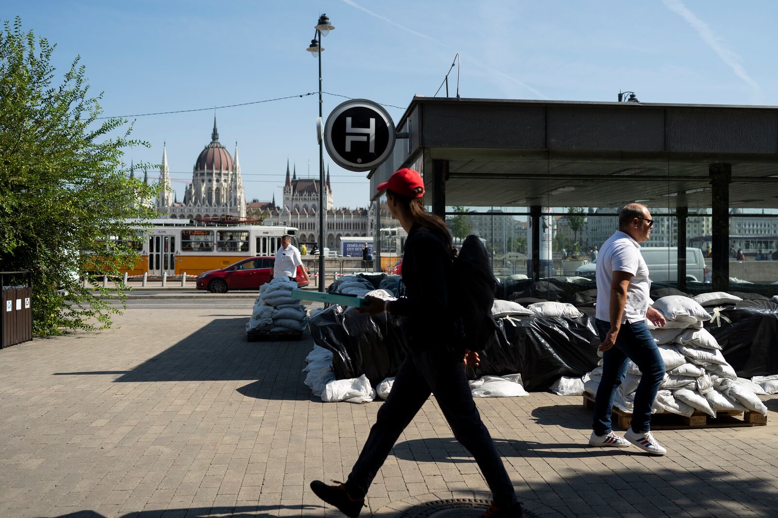 People walk by a metro station protected by sandbags as the Danube river floods it's banks, central Budapest, Hungary, Thursday, Sept. 19, 2024. (AP Photo/Denes Erdos)