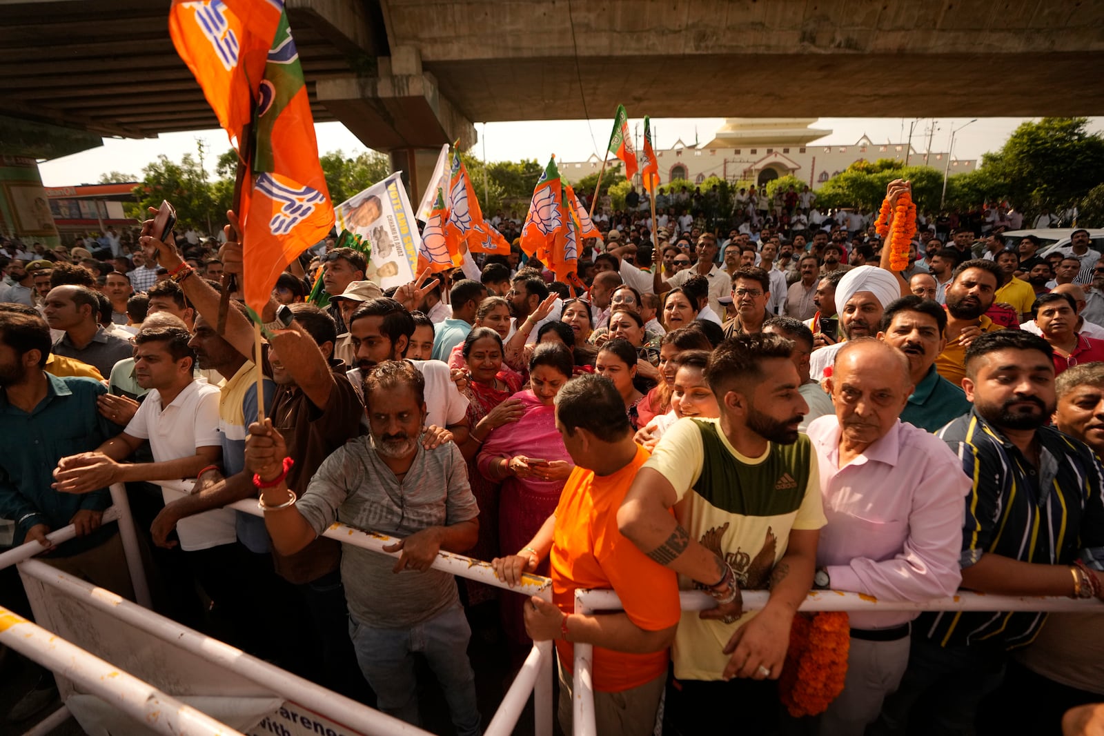 Bharatiya Janata Party (BJP) supporters hold party flags and wait outside a counting center in Jammu, India, Tuesday, Oct. 8, 2024. (AP Photo/Channi Anand)