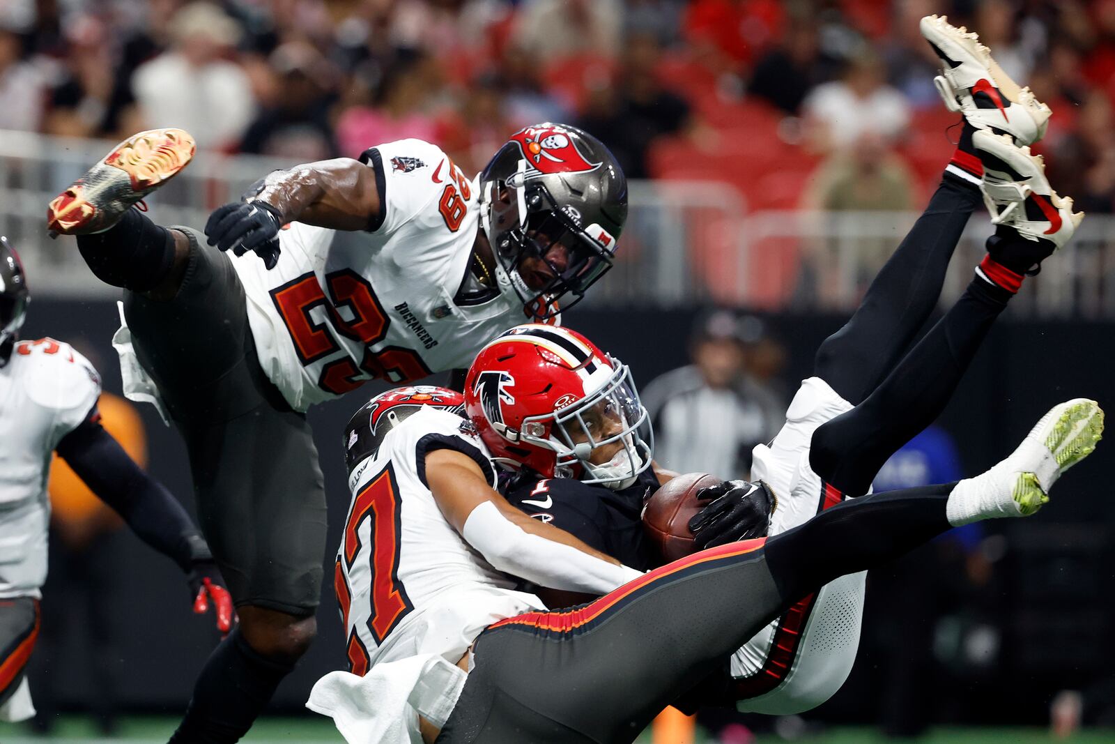 Atlanta Falcons wide receiver Darnell Mooney (1) makes a touchdown reception between Tampa Bay Buccaneers cornerback Zyon McCollum (27) and safety Christian Izien (29) during the first half of an NFL football game Thursday, Oct. 3, 2024, in Atlanta. (AP Photo/Butch Dill)