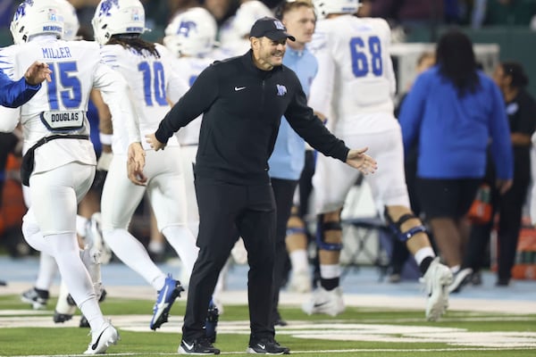 Memphis head coach Ryan Silverfield, center, welcomes his players as they come onto the field for an NCAA college football game against Tulane in New Orleans, Thursday, Nov. 28, 2024. (AP Photo/Peter Forest)