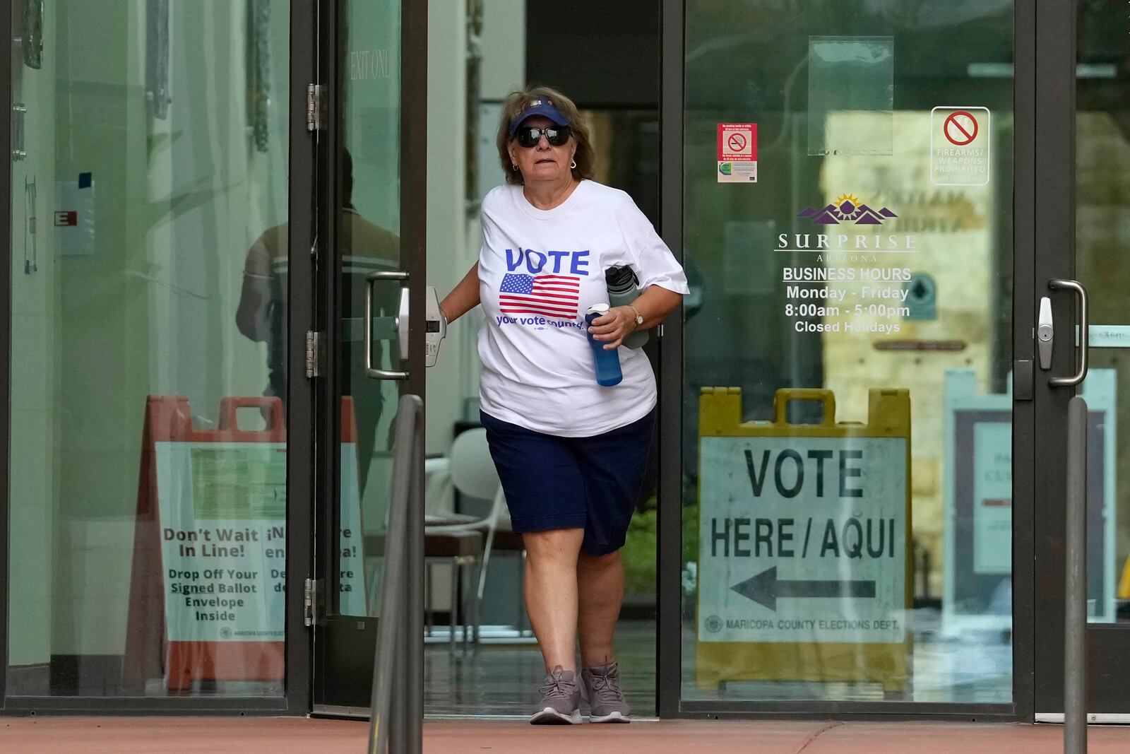 A voter leaves Surprise City Hall after voting on the first day of early in-person voting for the general election Wednesday, Oct. 9, 2024, in Surprise, Ariz. (AP Photo/Ross D. Franklin)