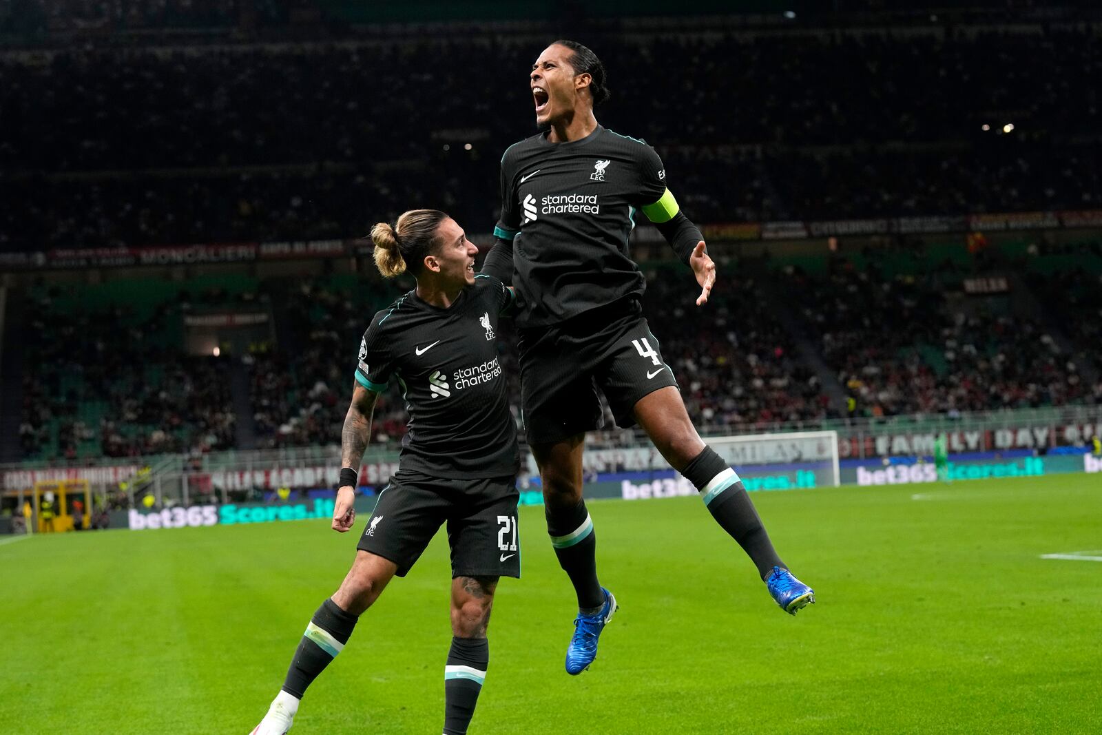 Liverpool's Virgil van Dijk, left, celebrates after scoring his side's second goal during the Champions League opening phase soccer match between AC Milan and Liverpool at the San Siro stadium in Milan, Italy, Tuesday, Sept. 17, 2024. (AP Photo/Antonio Calanni)