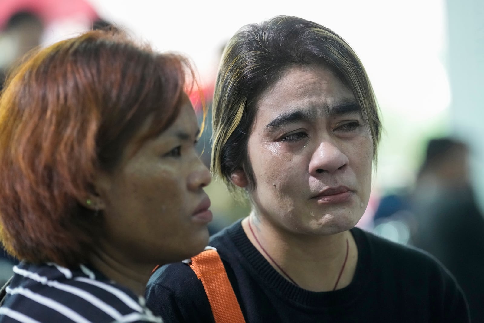 Relatives mourn nears the coffins of victims of school bus fire at Wat Khao Phraya Sangkharam School Lan Sak, Uthai Thani province, Thailand, Thursday, Oct. 3, 2024. (AP Photo/Sakchai Lalit)