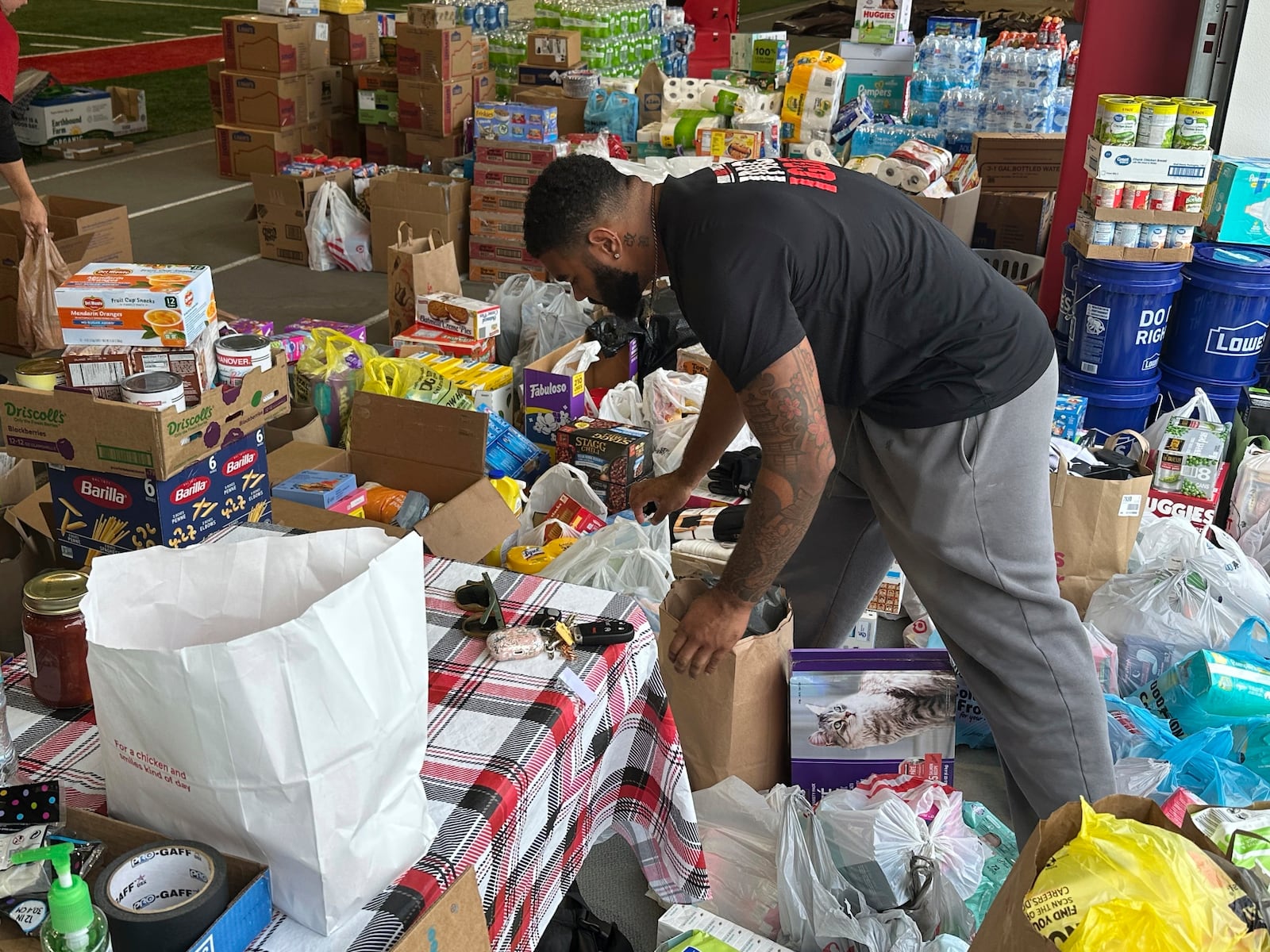 N.C. State defensive end Davin Vann works among the donations collected to help Hurricane Helene victims in western North Carolina, Wednesday, Oct. 2, 2024 in Raleigh, N.C. (AP Photo/Aaron Beard)