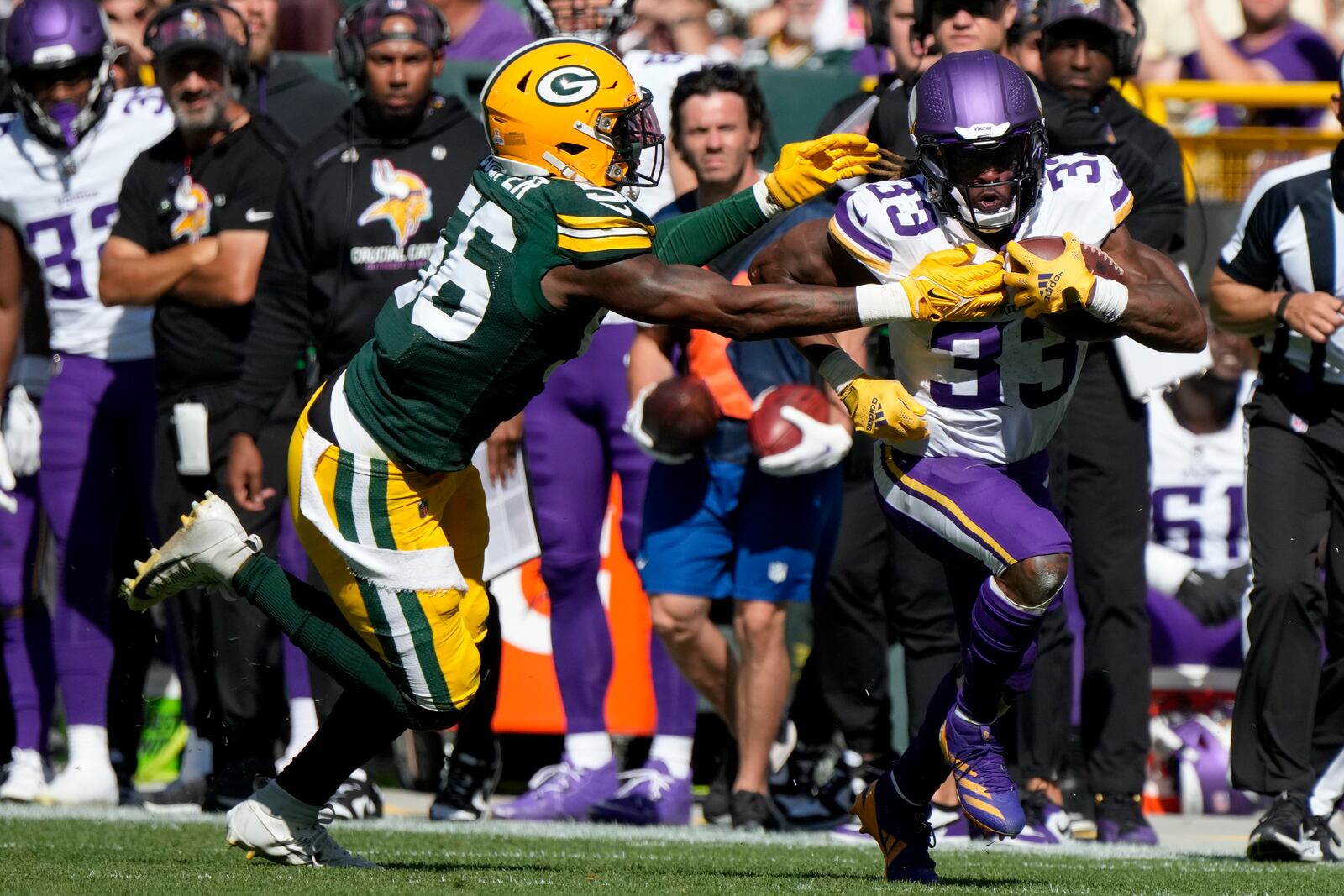 Minnesota Vikings running back Aaron Jones (33) runs the ball past Green Bay Packers linebacker Edgerrin Cooper, left, during the second half of an NFL football game Sunday, Sept. 29, 2024, in Green Bay, Wis. (AP Photo/Morry Gash)