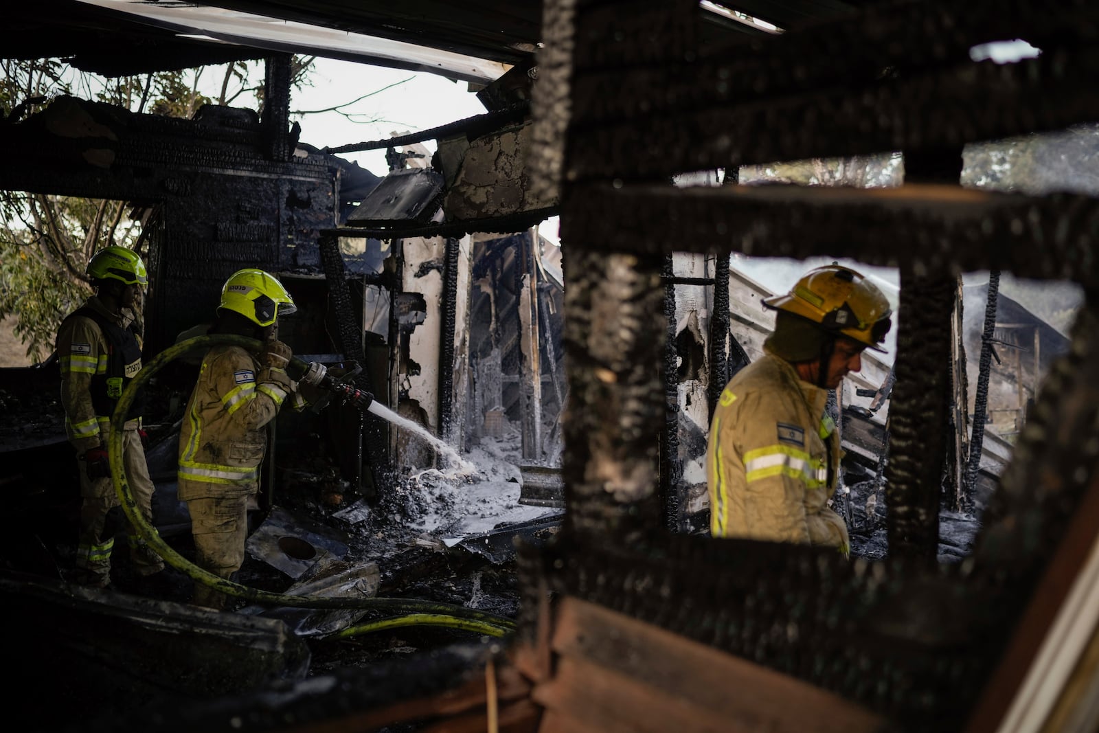 Israeli firefighters work at a house that was hit by a rocket fired from Lebanon, near the city of Safed, northern Israel, on Saturday, Sept. 21, 2024. (AP Photo//Leo Correa)