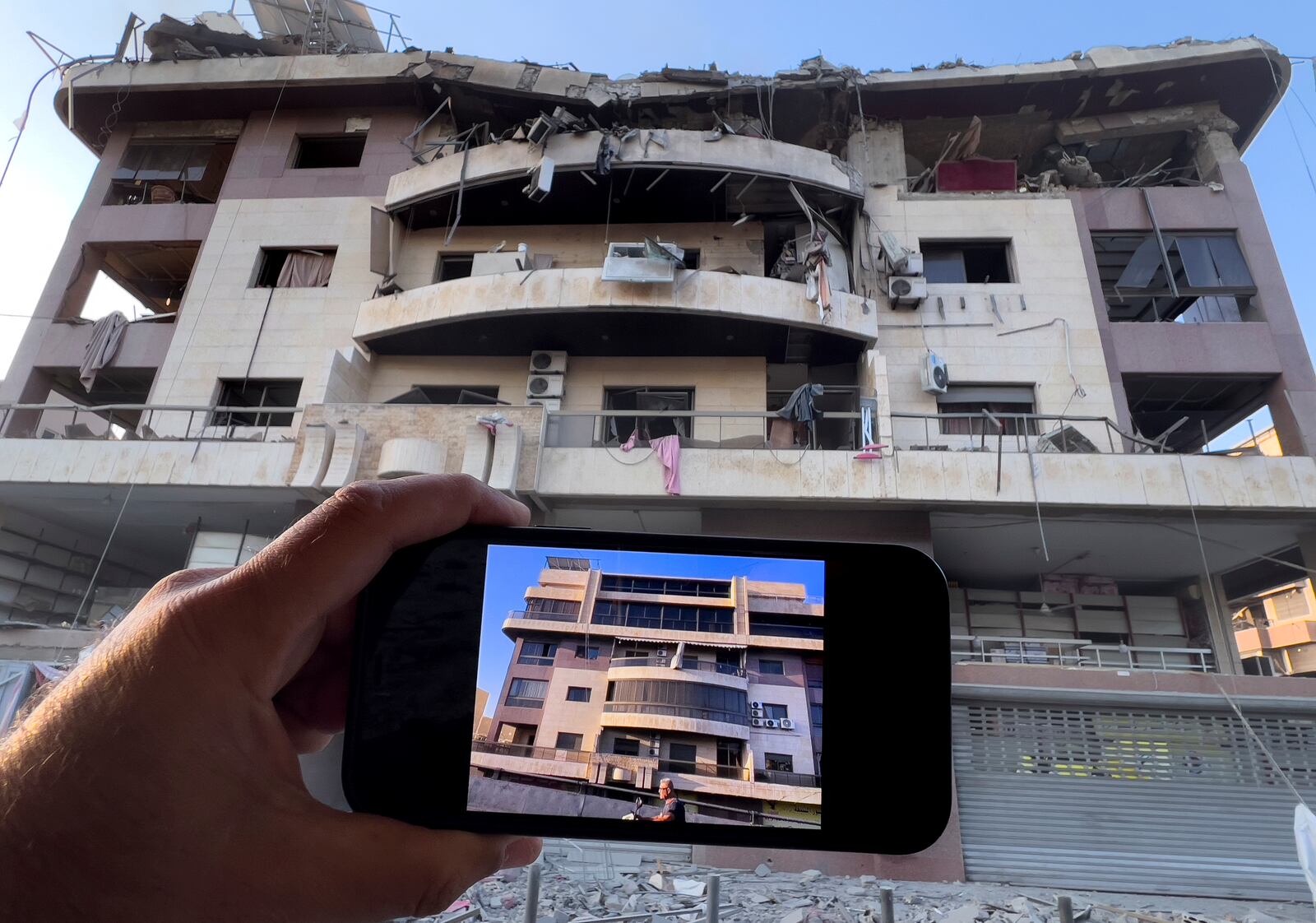 A man shows his newly duplex apartment on his mobile phone how it was before it was attacked by an Israeli airstrike on Dahiyeh, in the southern suburb of Beirut, Lebanon, Friday, Nov. 1, 2024. (AP Photo/Hussein Malla)