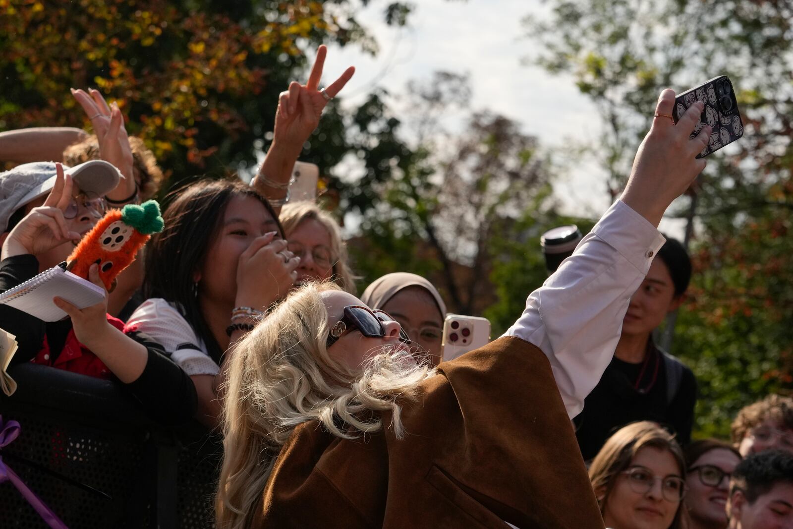 Nicola Coughlan takes photographs with fans as she departs the Gucci Spring Summer 2025 collection, that was presented in Milan, Italy, Friday, Sept. 20, 2024. (AP Photo/Luca Bruno).