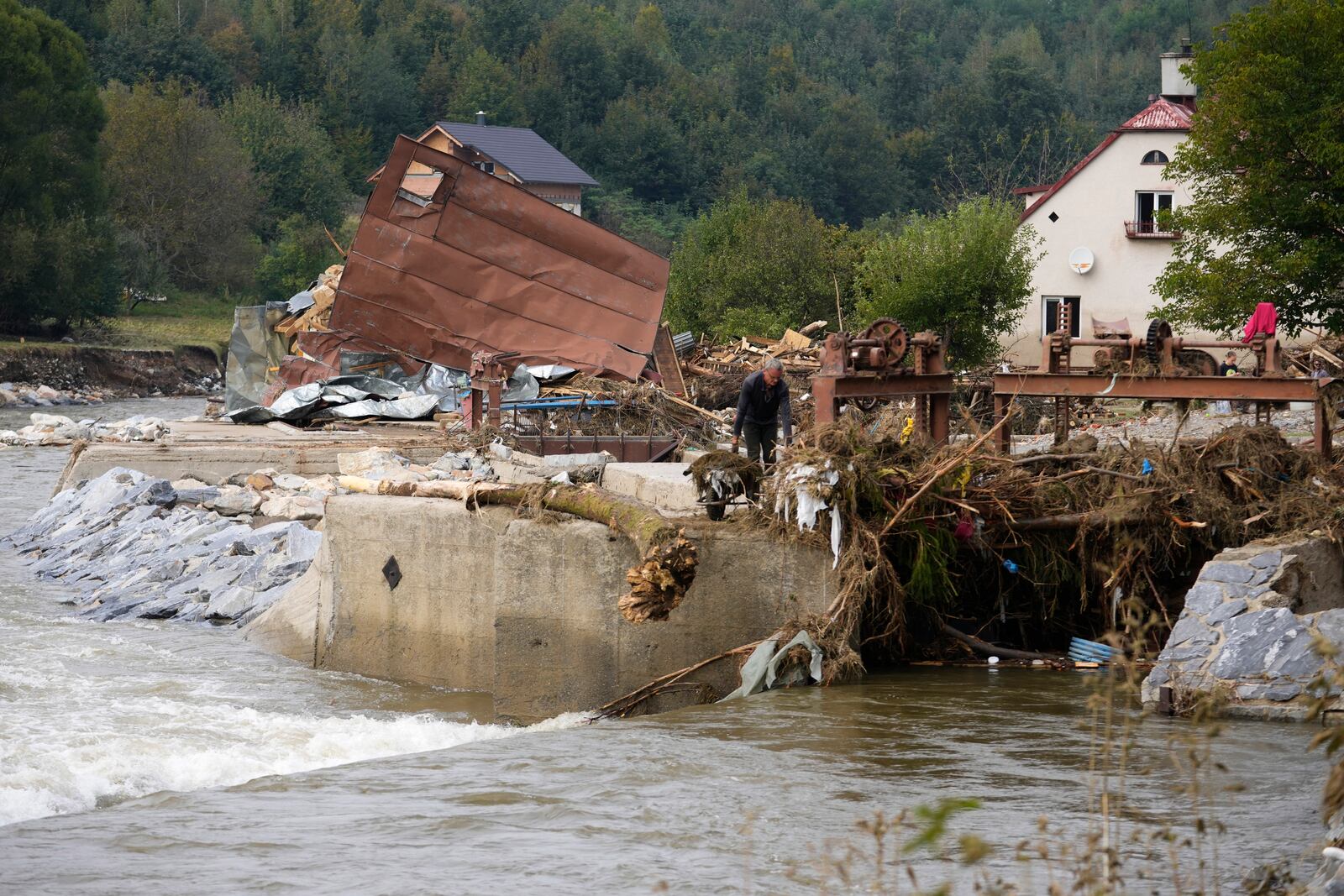 A man barrows out mud as residents return to clean up after recent floods in Mikulovice, Czech Republic, Thursday, Sept. 19, 2024. (AP Photo/Petr David Josek)