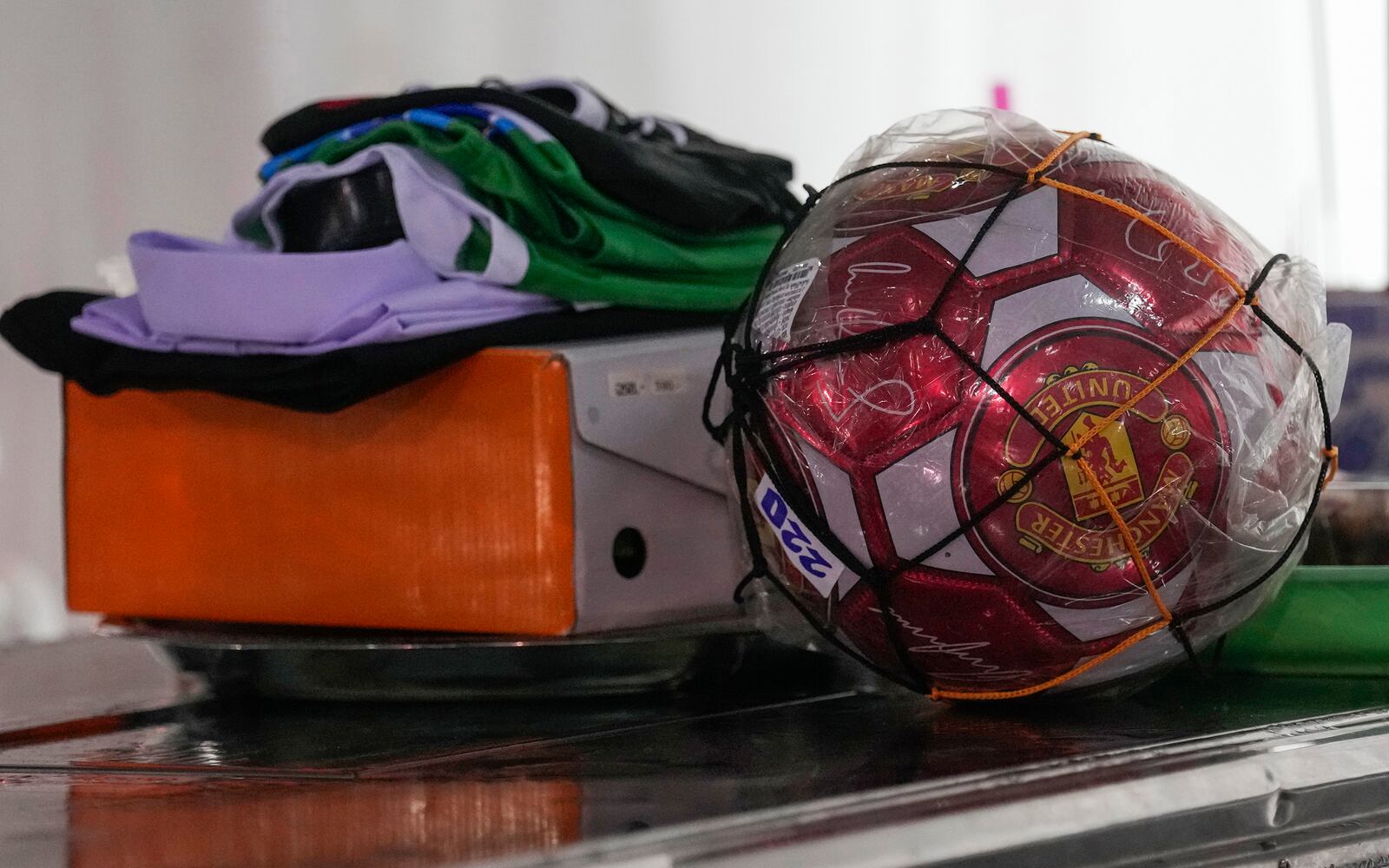 A newly purchased football is kept near the coffin of one of the victims of the school bus fire by father Wichan Seubsaichan, at Wat Khao Phraya Sangkharam School, Lan Sak, Uthai Thani province, Thailand, Thursday, Oct. 3, 2024. (AP Photo/Sakchai Lalit)