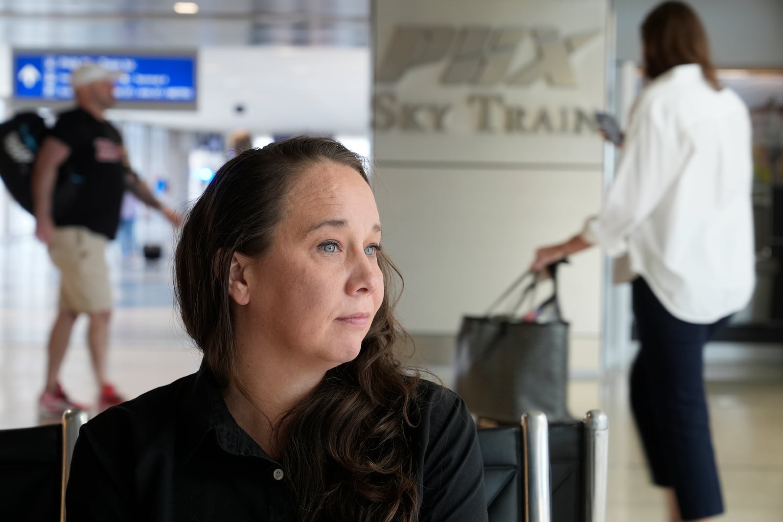 Lindsay Ruck, a server at Phoenix Sky Harbor International Airport restaurants, pauses in Terminal 3 as she works for minimum wage plus tips and is interested in the upcoming election and the Arizona Prop 138 on minimum wage vote Thursday, Oct. 3, 2024, in Phoenix. (AP Photo/Ross D. Franklin)