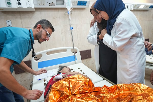 A child wounded during an Israeli army airstrike talks with two women as a medic stands by at a hospital in Deir al-Balah, Gaza, late Saturday Nov. 16, 2024. Palestinian medical officials reported Sunday that Israeli strikes on the Gaza Strip overnight killed 12 people.(AP Photo/Abdel Kareem Hana)