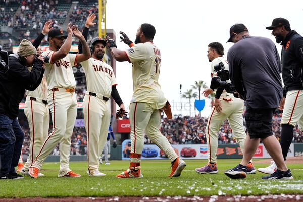 San Francisco Giants' Heliot Ramos (17) celebrates with teammates after the team's victory over the Texas Rangers in a baseball game Sunday, April 27, 2025, in San Francisco. (AP Photo/Godofredo A. Vásquez)
