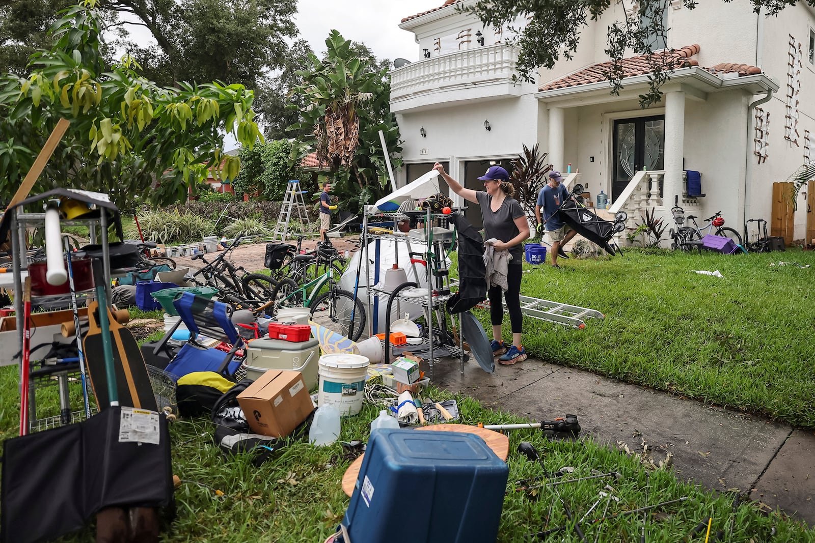 Ellie Moss, along with family and friends cleans contents of her home after flooding from Hurricane Helene on Davis Island Saturday, Sept. 28, 2024, in Tampa, Fla. (AP Photo/Mike Carlson)