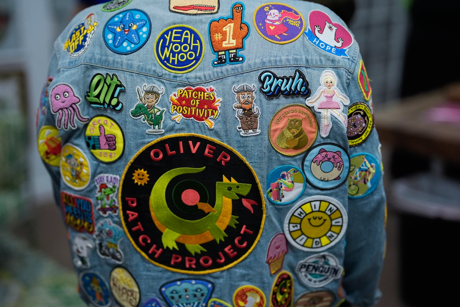 Brian Burkhardt, who runs the Oliver Patch Project which the family started after seeing how much donated patches boosted the morale of son Oliver when he underwent cancer treatment at age 9, wears a jacket covered with patches inside the charity's office, Wednesday, Sept. 4, 2024, in Miami. (AP Photo/Rebecca Blackwell)