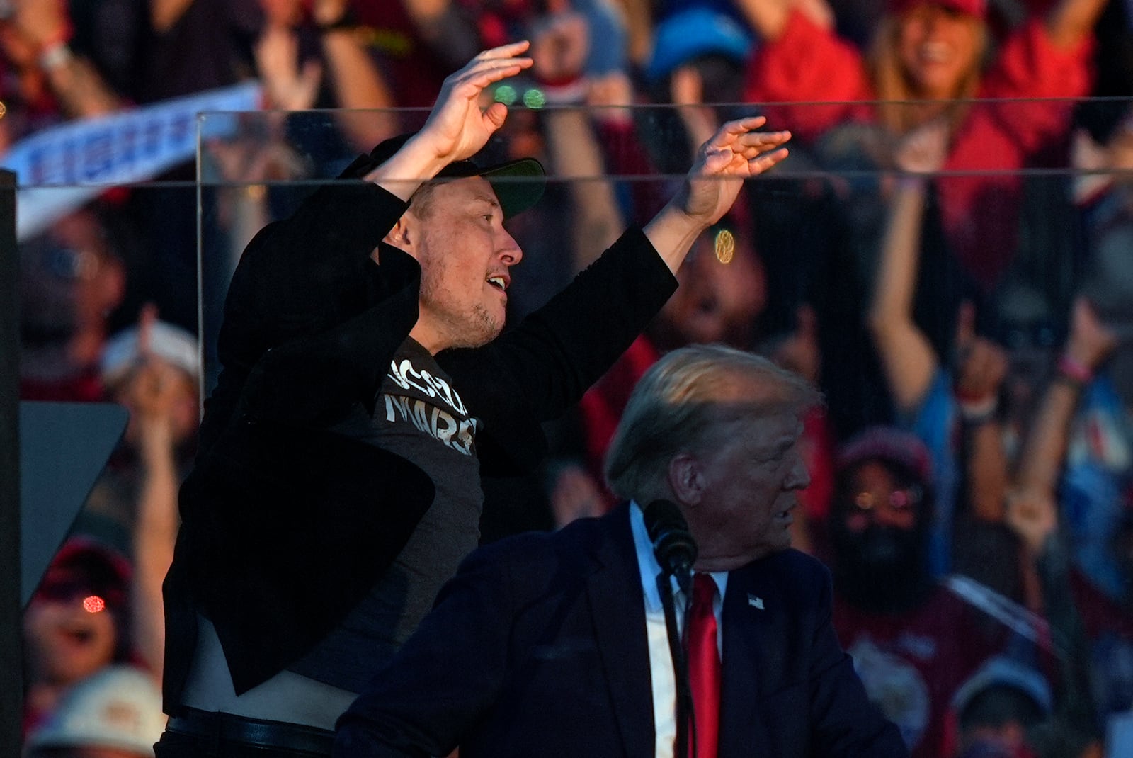 Elon Musk jumps on the stage behind Republican presidential nominee former President Donald Trump during a campaign rally at the Butler Farm Show, Saturday, Oct. 5, 2024, in Butler, Pa. (AP Photo/Julia Demaree Nikhinson)