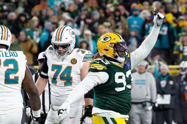 Green Bay Packers defensive tackle T.J. Slaton (93) celebrates in front of Miami Dolphins offensive tackle Liam Eichenberg (74) after a defensive stop during the second half of an NFL football game Thursday, Nov. 28, 2024, in Green Bay, Wis. (AP Photo/Mike Roemer)