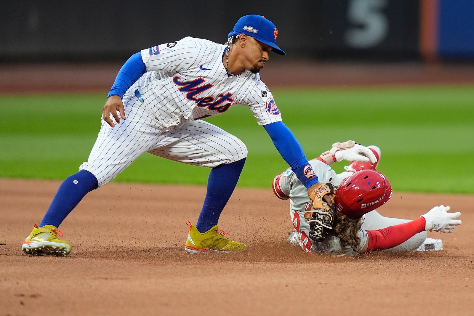 New York Mets shortstop Francisco Lindor (12) tags out Philadelphia Phillies' Alec Bohm (28) as Bohm attempts to stretch a base hit into a double during the fourth inning of Game 3 of the National League baseball playoff series, Tuesday, Oct. 8, 2024, in New York. (AP Photo/Frank Franklin II)