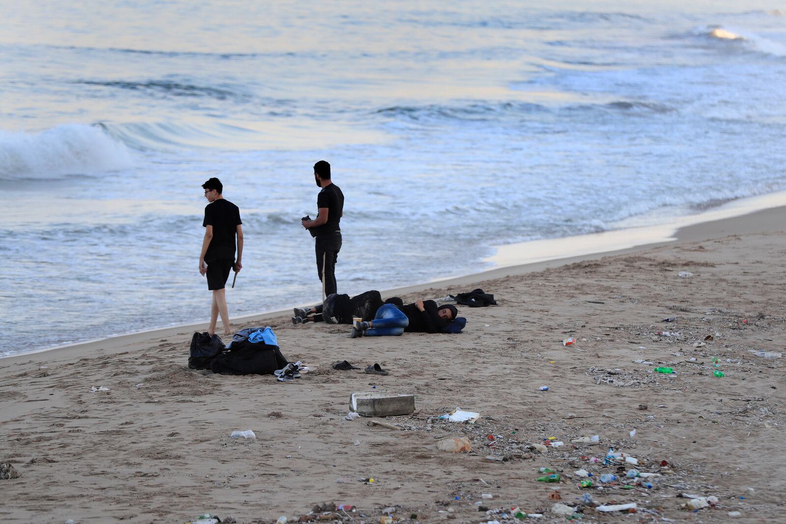 Lebanese men who fled on the southern villages amid ongoing Israeli airstrikes Monday, sleep on a public beach in the southern port city of Sidon, Lebanon, Tuesday, Sept. 24, 2024. (AP Photo/Mohammed Zaatari)