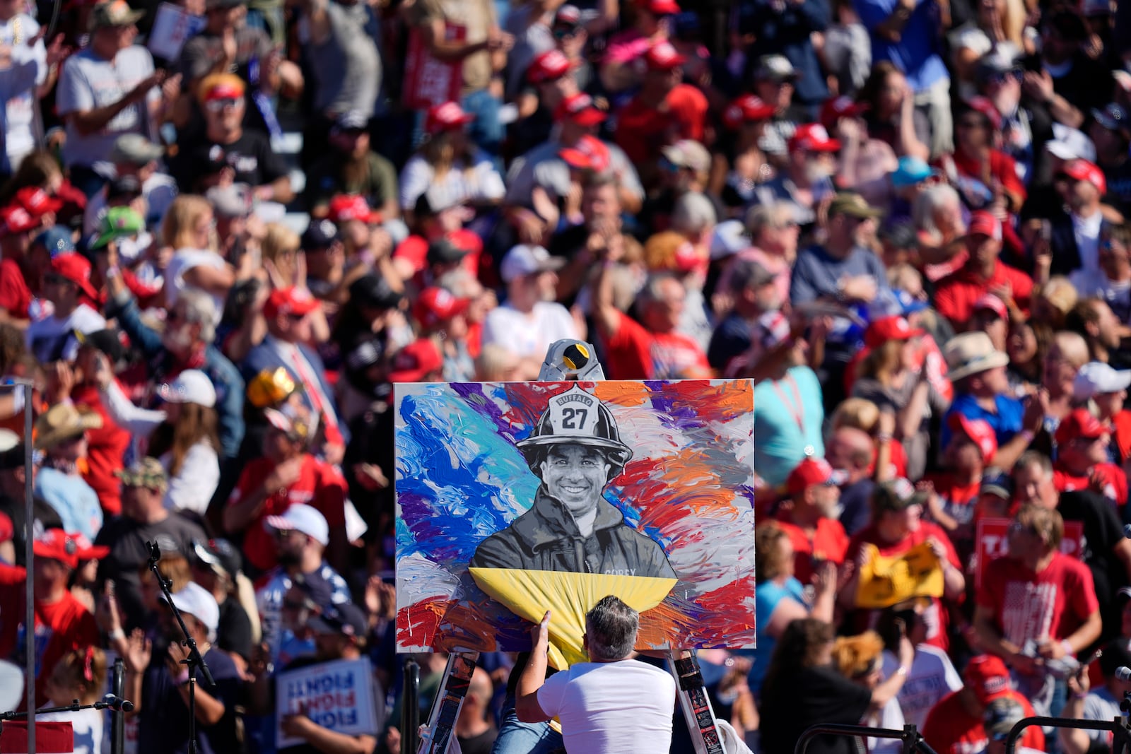 Artist Scott LaBaido unveils a painting of Corey Comperatore before Republican presidential nominee former President Donald Trump speaks at a campaign rally at the Butler Farm Show, Saturday, Oct. 5, 2024, in Butler, Pa. (AP Photo/Julia Demaree Nikhinson)