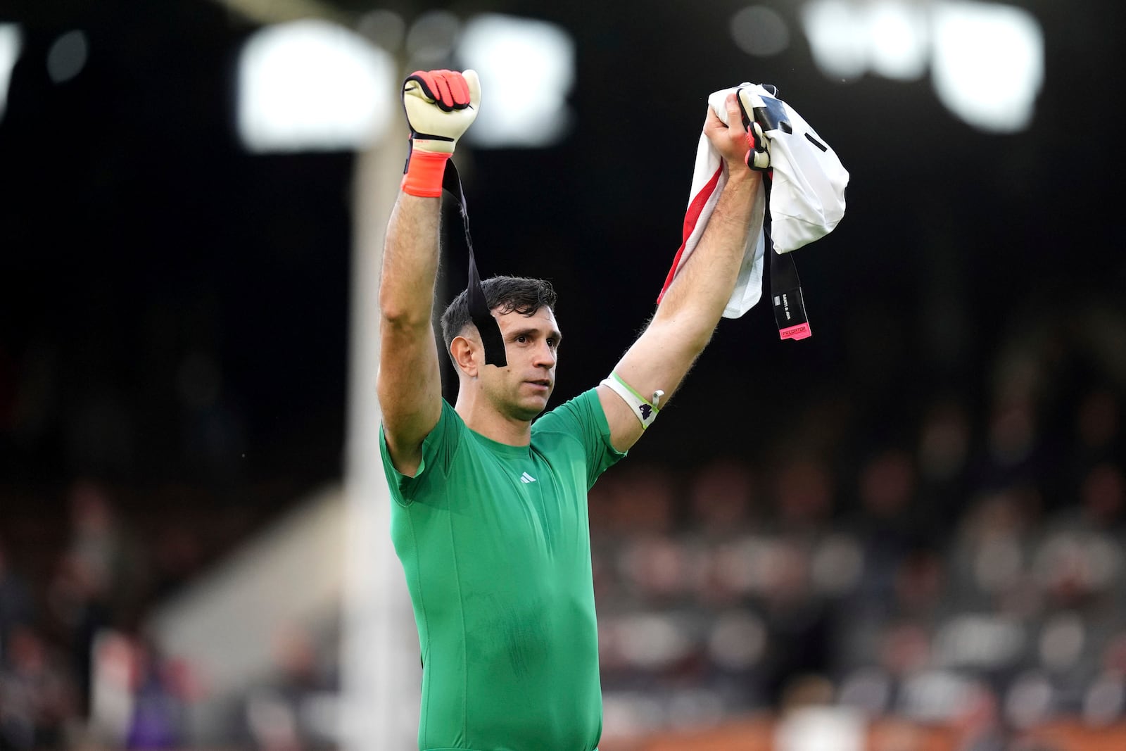 Aston Villa goalkeeper Emiliano Martinez celebrates in front of the fans after the final whistle in the English Premier League soccer match between Fulham and Aston Villa at Craven Cottage, London, Saturday Oct. 19, 2024. (John Walton/PA via AP)