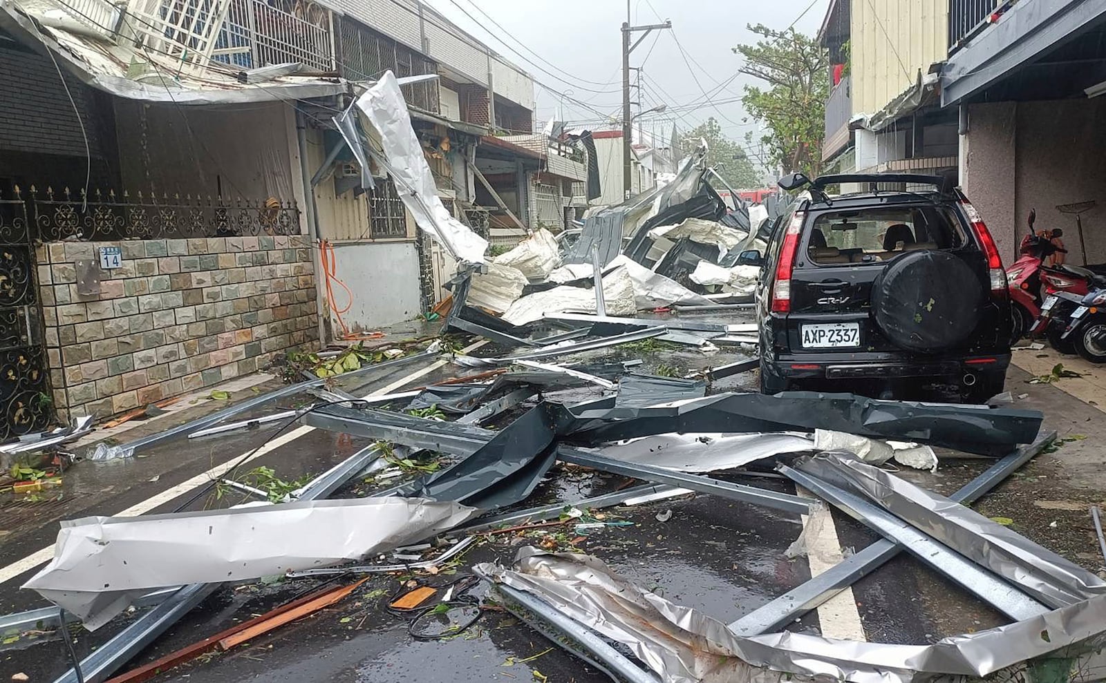 In this photo released by Hualien County Fire Department, a blown roof destroyed by the wind of Typhoon Kong-rey, lay across a road in Hualien County, eastern Taiwan, Thursday, Oct. 31, 2024. (Hualien County Fire Department via AP)