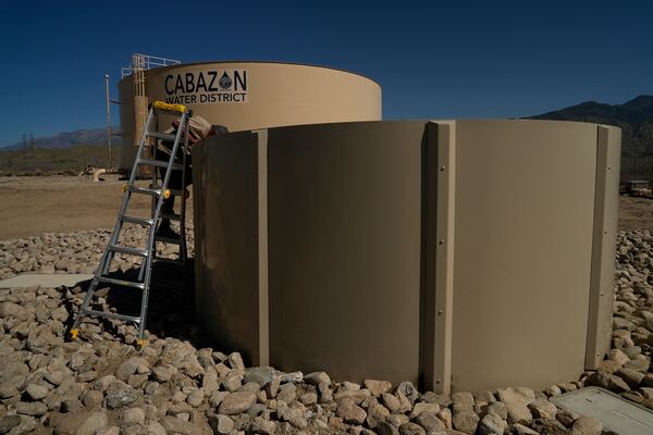 Glenn Chavez tests a newly installed Heli-Hydrant, a small, open tank that helicopters can rely on to get water faster for urban fires, Friday, April 11, 2025, in Cabazon, Calif. (AP Photo/Brittany Peterson)