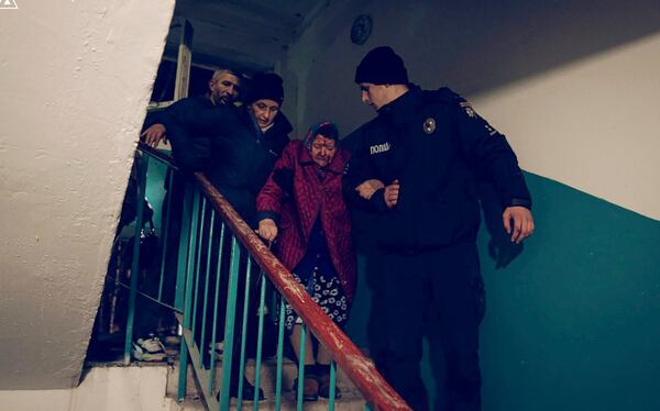 In this photo provided by the Ukrainian Emergency Service, a police officer, right, evacuates an elderly resident following a Russian rocket attack that hit a multi-storey apartment building in Sumy, Ukraine, Sunday, Nov. 17, 2024. (Ukrainian Emergency Service via AP)