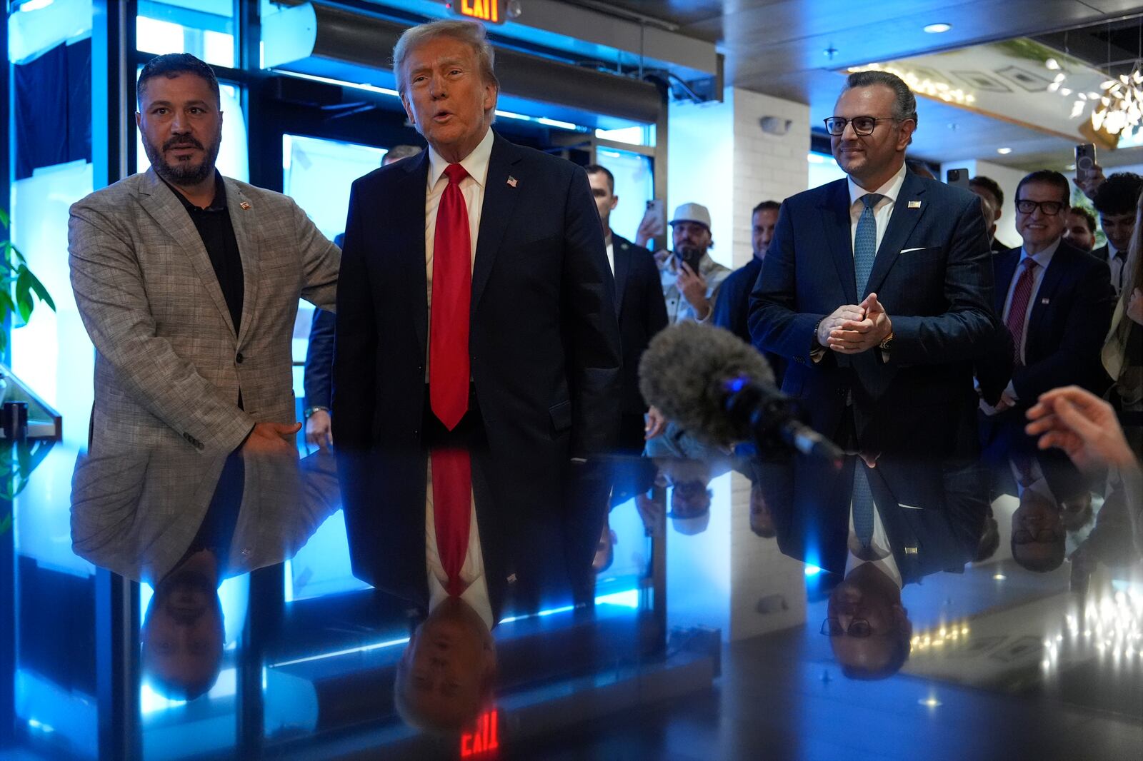 Republican presidential nominee former President Donald Trump visits The Great Commoner, Friday, Nov. 1, 2024, in Dearborn, Mich., as owner Albert Abbas, left, escorts him and Massad Boulos watches, (AP Photo/Julia Demaree Nikhinson)