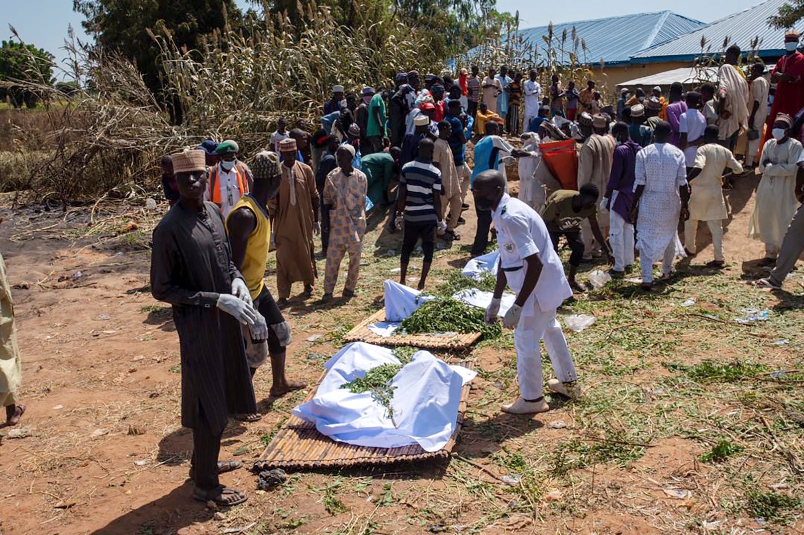 People prepare bodies for funeral following a tanker explosion in Majiya town Nigeria, Wednesday, Oct.16, 2024. ( AP Photo/ Sani Maikatanga)