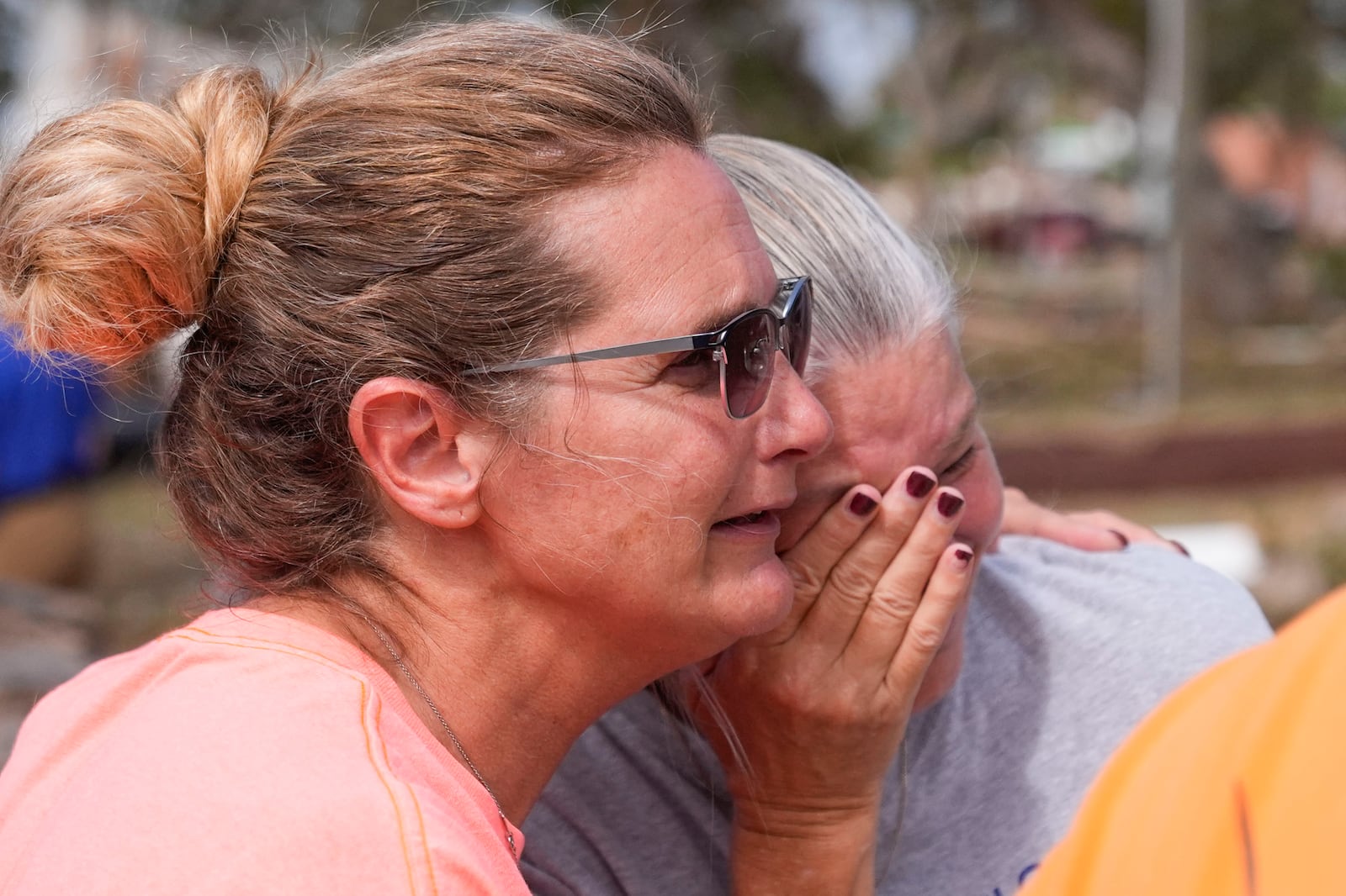 Tammy Bryan, left, hugs fellow resident Jennifer Lange amid the destruction in the aftermath of Hurricane Helene, in Horseshoe Beach, Fla., Saturday, Sept. 28, 2024. (AP Photo/Gerald Herbert)