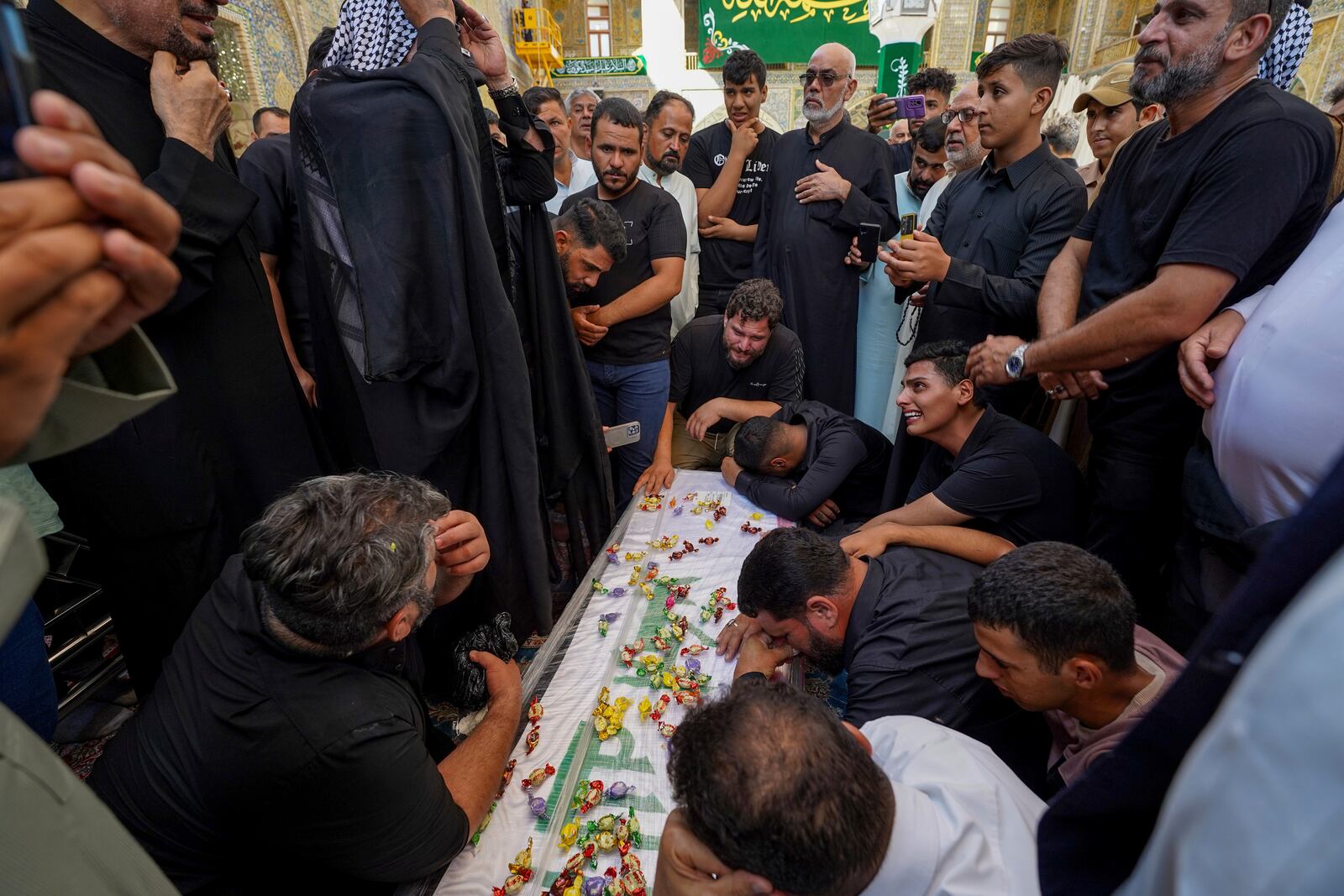 Relatives mourn over the coffin of Zulfikar Dergham Musa Al-Jabouri, in Najaf, Iraq, Thursday, Sept. 26, 2024 who died in Israeli airstrikes on Sept. 23 fighting alongside Hezbollah in Tyre, south Lebanon. (AP Photo/Anmar Khalil)