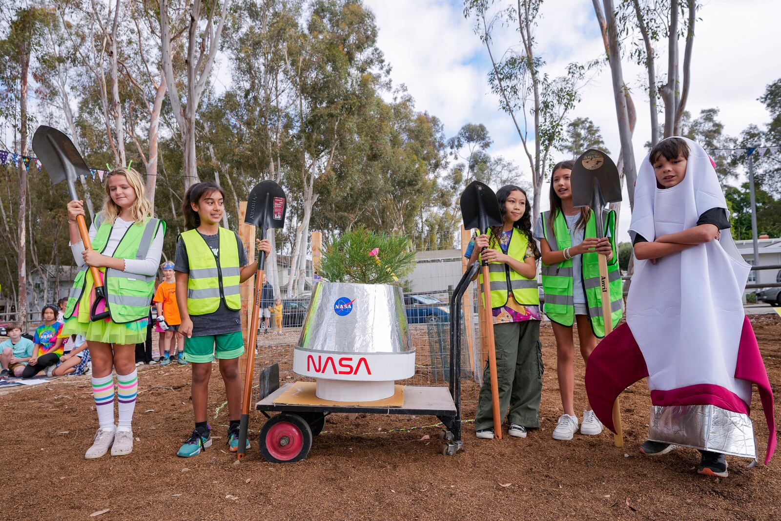 Students at Santiago STEAM Magnet Elementary School participate at a ceremony to plant a small Giant Sequoia tree from NASA's Artemis I Mission's tree seeds that traveled around the moon twice, after the school was honored in the spring of 2024 to become NASA Moon Tree Stewards in Lake Forest, Calif., on Monday, Oct. 14, 2024. (AP Photo/Damian Dovarganes)